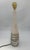 The alabaster lamp features a slender and elegant shape, with a tapered base reminiscent of a contemporary obelisk. The...