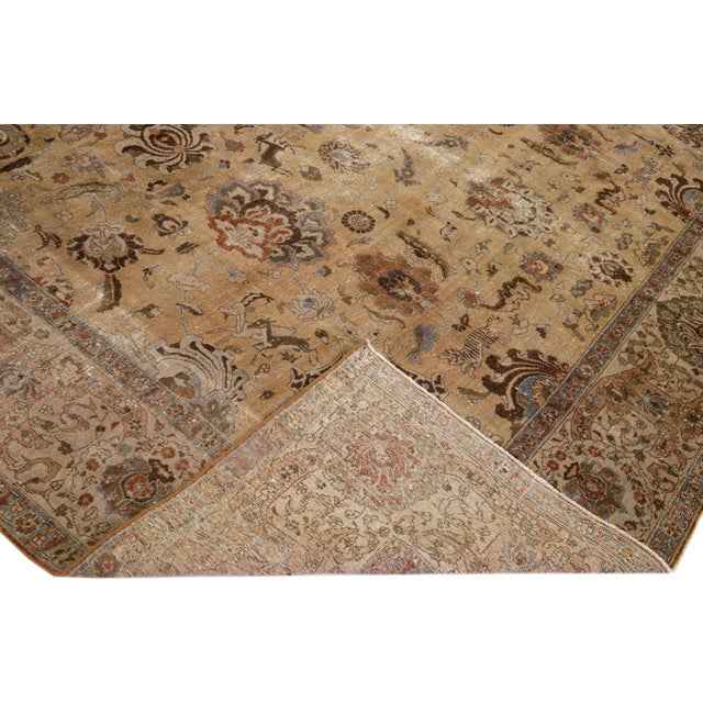 Beautiful antique Tabriz hand-knotted wool rug with a brown color field. This Persian rug has blue, green, and rust...