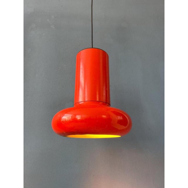 Vintage space age pendant lamp in red/orange colour. The shade is made out of metal and has an red/orange lacquer. The...
