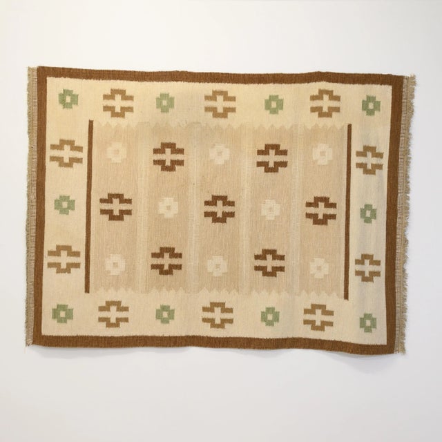 Large mid-century Swedish Kilim in tones of browns and creams decorated with medallions and bordered in dark brown....