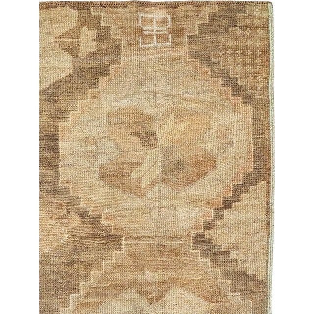 This mid-20th-century Turkish Anatolian accent rug presents a bold allover arrangement of large stepped medallions in...