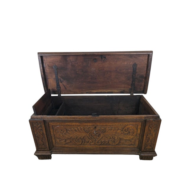 A rustic chest in walnut, Italy, dated 1799. The date is carved into the front panel, set in a scroll of leaves and...