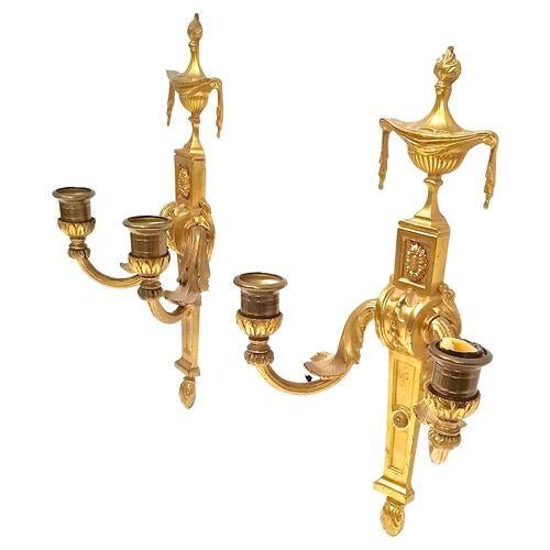 Pair of antique gilt brass Empire style wall candle sconces with flaming urn with drapery motif at top resting on a plinth...