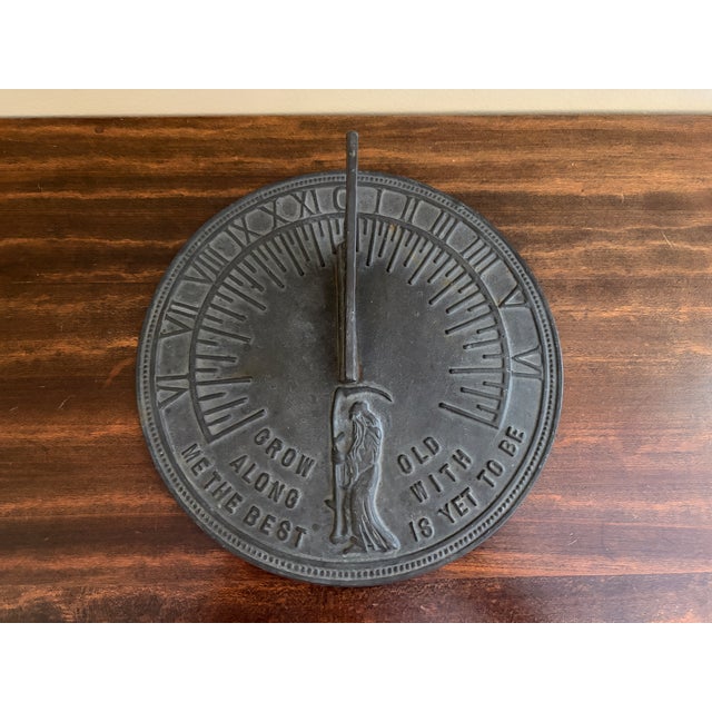 A classic vintage iron garden sundial inspired by traditional English estate landscapes, reading "Grow old along with me....
