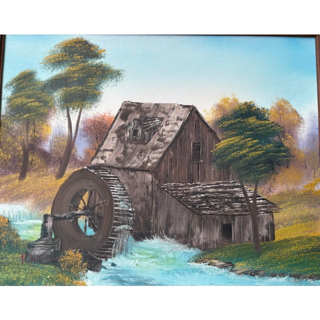 This vintage oil painting depicts a charming rustic water mill set within a peaceful countryside landscape. The scene...