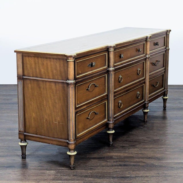 This Dixon-Powdermaker dresser features nine spacious drawers and a classic wood finish. Its brass handles and accents add...