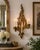A striking vintage Hollywood Regency wall sconce featuring an ornate three-arm design with stylized acanthus leaves and...