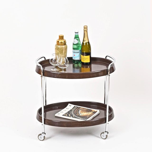 Wonderful Mid-Century oval bar cart in deep brown ABS plastic and chromed metal. This delightful and rare piece was...