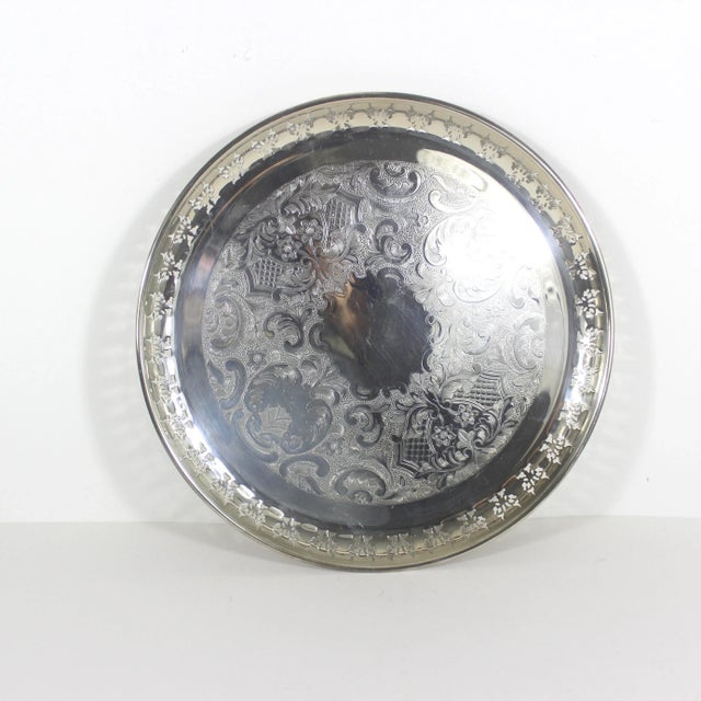 13.5” large vintage round silver plated tray with pierced edge, embossed base and small feet. This has recently been...