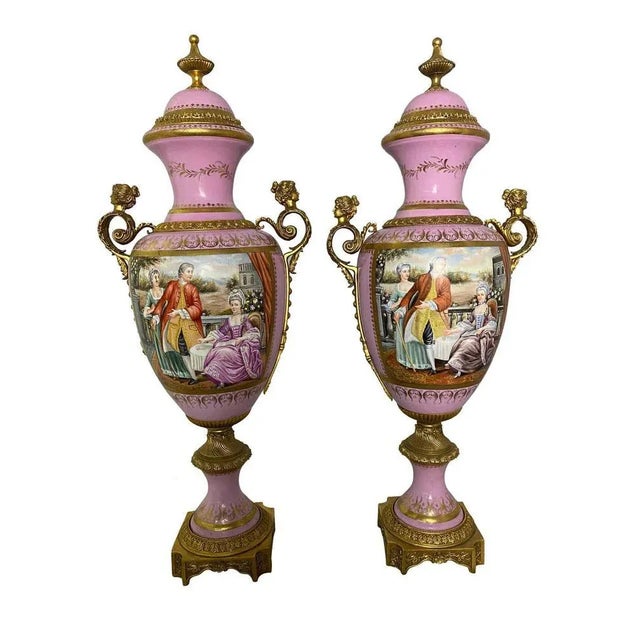 A pair of french sèvres marked monumental pink vases with hand painted scenes depicting french lovers dining at a garden...
