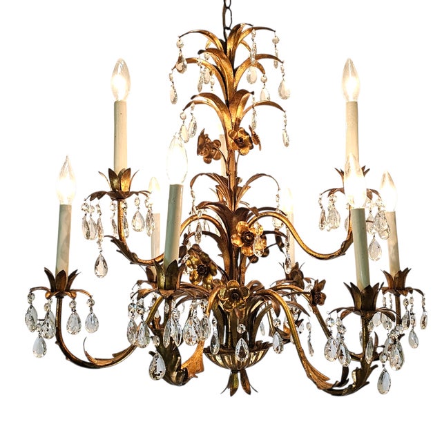Vintage Italian 9-arm gilt tole chandelier with crystal drop prisms. Features gold leaf floral bobeches, curling acanthus...