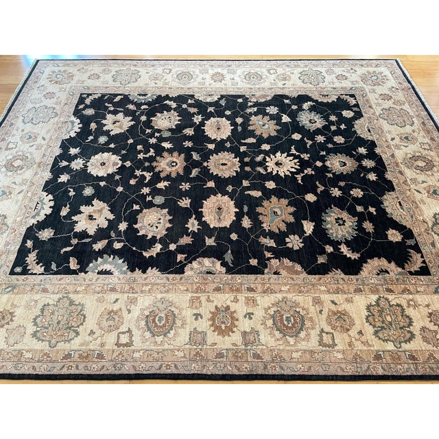This is a Ziegler Sultanabad rug, hand-knotted with wool. It features a deep black field with large floral motifs in muted...