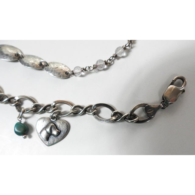 Pair of sterling silver link bracelets circa late 20th century. One with dog charms and St. Francis of Assisi charm, the...
