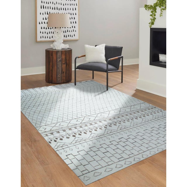 A hand-knotted wool rug, made in India and measuring 4' x 6'. Floral drawing carried across the field inside a traditional...