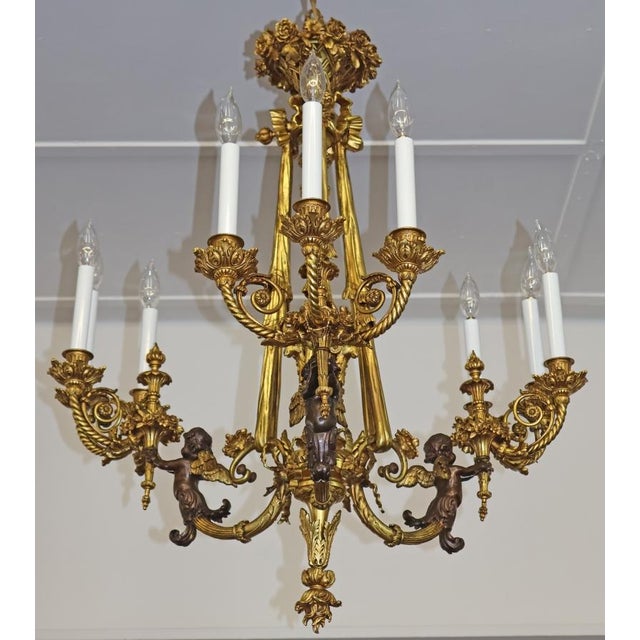 Late 19th Century French Belle Epoque Bronze Putti Cherub 9 Light Chandelier Dimensions : 32" Tall X 30" Wide X 30" Deep...