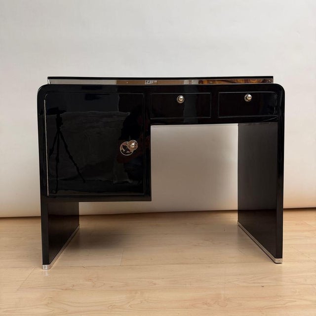 Elegant small Art Deco desk from France, circa 1930. High-gloss black piano lacquer. Original, newly nickel-plated metal...