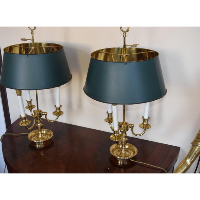 Pair of French Empire style bouillotte table lamps dating to the 1960s. Each lamp has three curved brass arms with candle-...