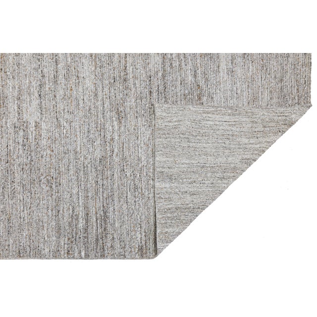 This sophisticated area rug combines ancient weaving techniques with modern sustainable materials. Crafted using a Soumak...