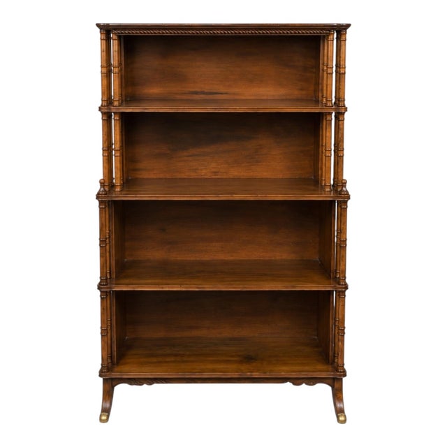 This is a late 20th century regency revival style faux bamboo bookcase. It has faux bamboo carved spindles, the top two...