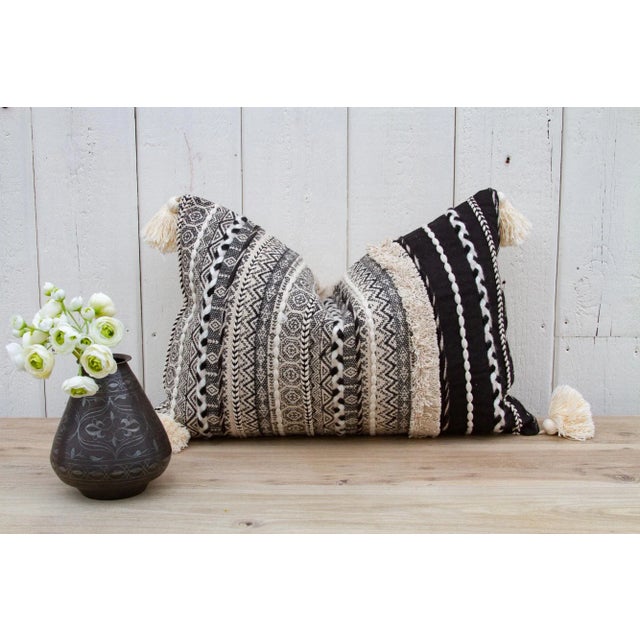 A tribal Beni Ourain cotton lumbar pillow. This Moroccan pillow shows patterns and designs traditional to tribes of the...