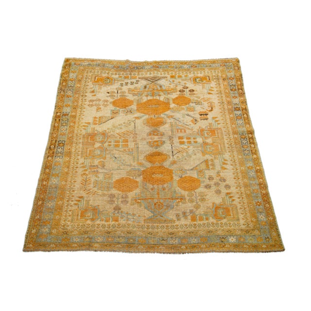 Beautiful antique Persian hand-knotted wool rug with a tan color field. This piece has a blue-designed frame with orange...