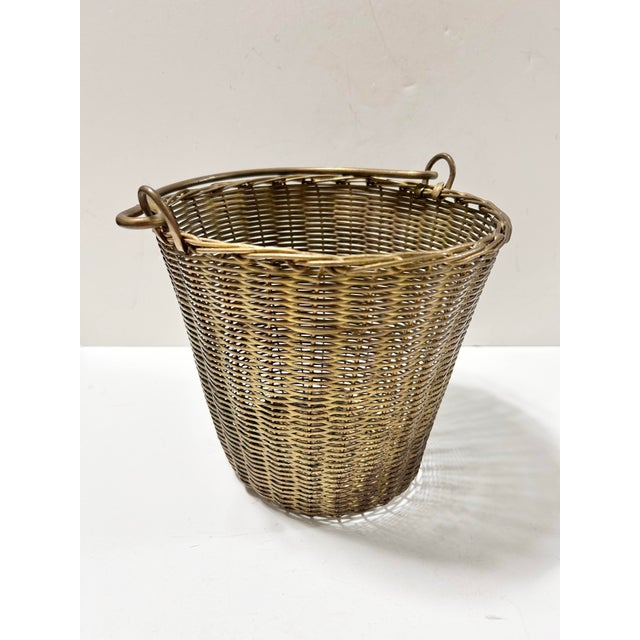 A finely woven vintage solid brass basket with sculptural looped swing handles and a rich, naturally aged patina. The...