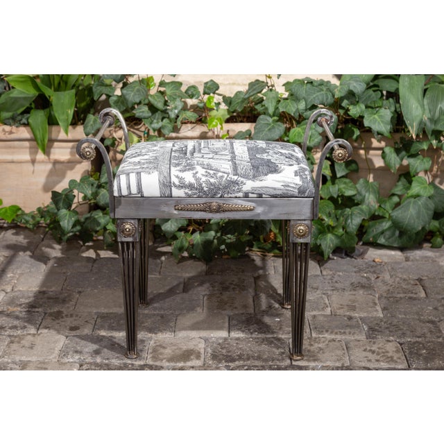 A French steel bench from the mid-20th century, with out-scrolling arms, tapered legs and classical-themed toile...