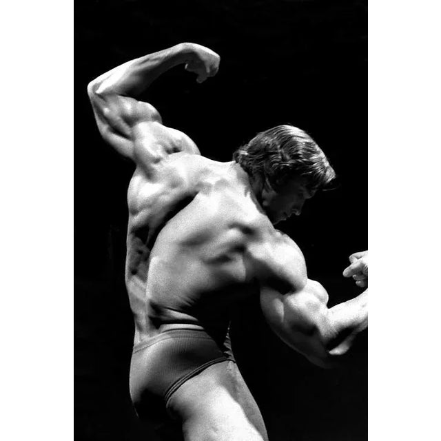 Arnold Schwarzenegger Flexing A Vintage 1976 image depicting a young Arnold Schwarzenegger, the champion bodybuilder who...