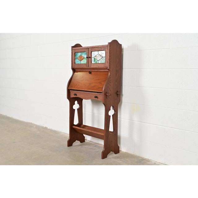 A gorgeous antique Mission or Arts & Crafts period drop front secretary desk or writing desk with book trough base In the...