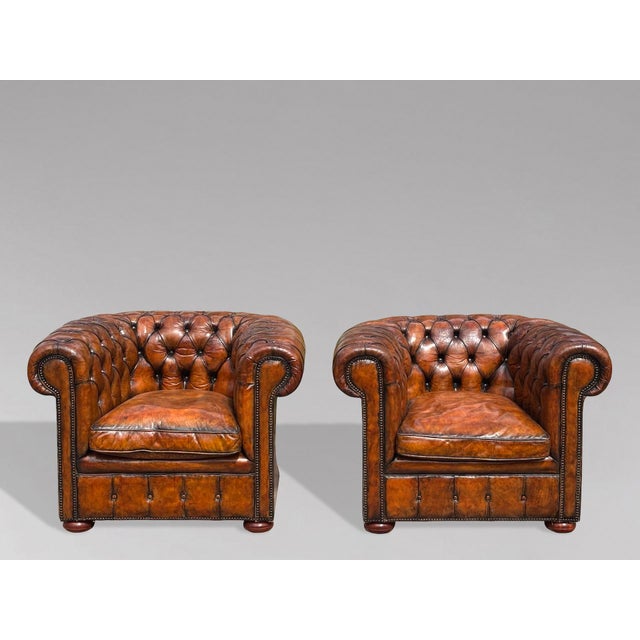A fine quality pair of late 19th-century Victorian beige leather Chesterfield club armchairs, retaining their original...