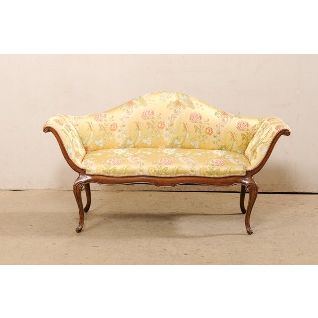 An Italian Venetian style carved wood & upholstered sofa from the early 19th century. This antique settee from Italy...