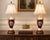 A charming pair of vintage porcelain table lamps featuring rich ruby-red grounds accented with cream porcelain, gilt...