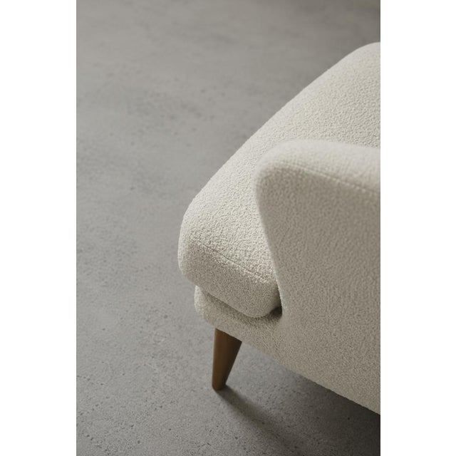 This low modernist armchair was produced in Scandinavia during the 1960s. It is characterized by a rounded backrest that...