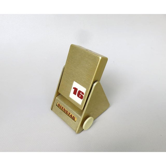 An eternal calendar in the design of the 1960s, described under the status with FWK. The aluminum housing is anodized gold...