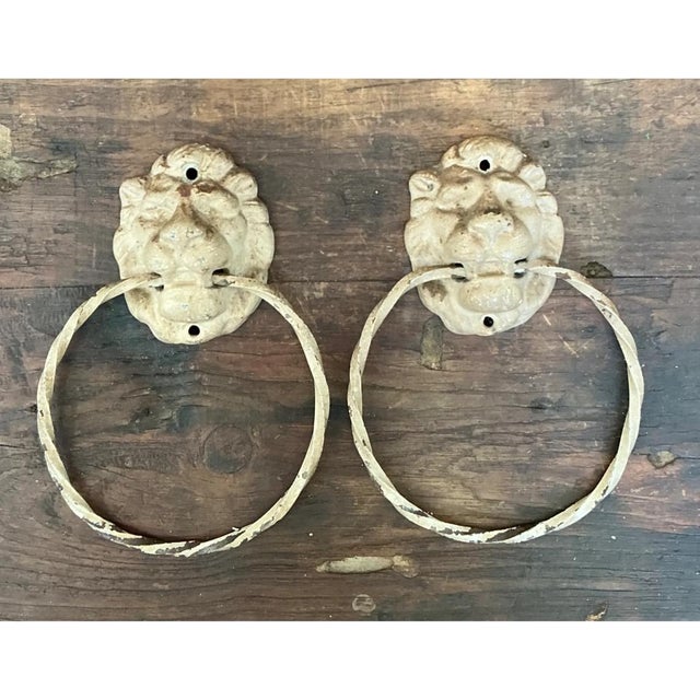 This pair of vintage lion head wall-mounted towel holders showcases the substantial character of early 20th-century cast...