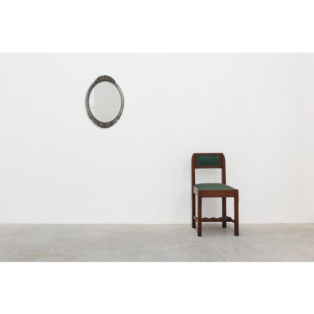 A refined French Art Deco oval wall mirror dating from the 1920s, distinguished by its elegantly carved wooden frame...