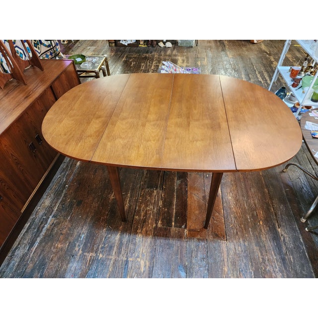 Bring home one of the most iconic Mid Century Modern designs with this vintage Broyhill Brasilia drop leaf dining table....