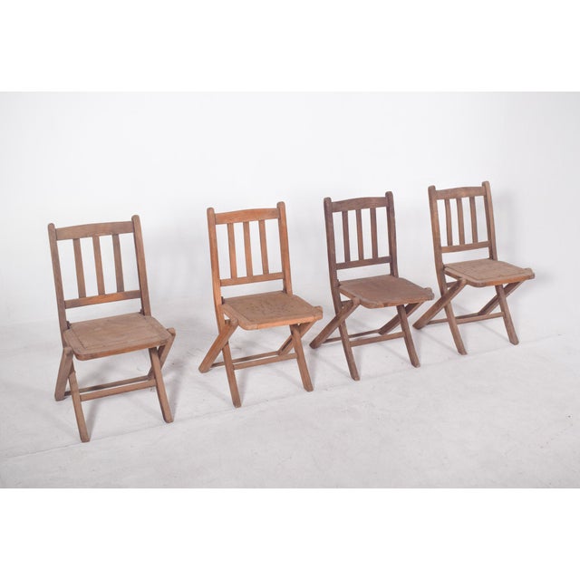 Set of four wooden folding chairs. with a folding structure that allows for easy storage and transportation. Each chair...