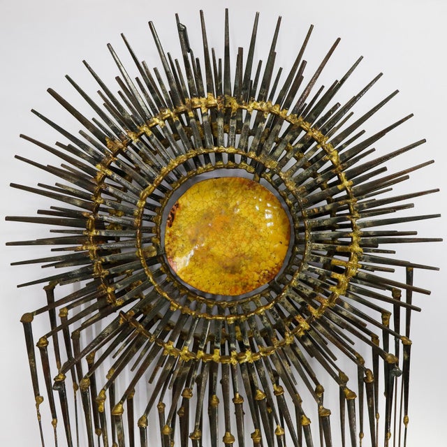 circa 1960. We offer this Brutalist metal wall sculpture. Made in iron, brass and enamel center. Signed by C. PARKER.