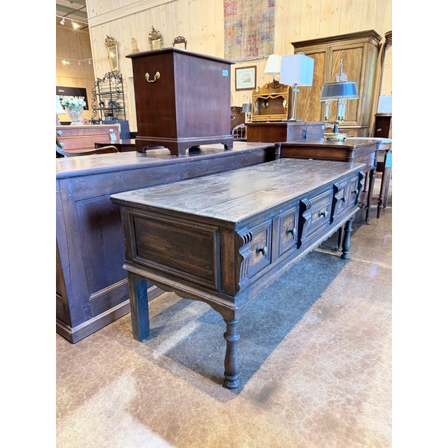 A handsome antique Jacobean Revival server with the substantial architectural character associated with early English...