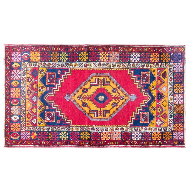 A striking 1930s Anatolian rug, handwoven in Turkey with a saturated crimson ground and a bold stepped medallion in shades...