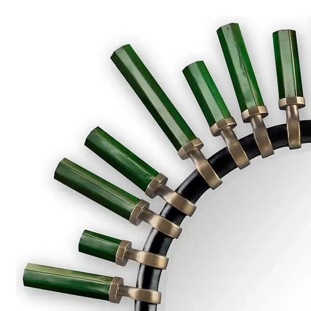 A sculptural round mirror by Christopher Guy, model Quartz. The design features a radiating frame composed of elongated...