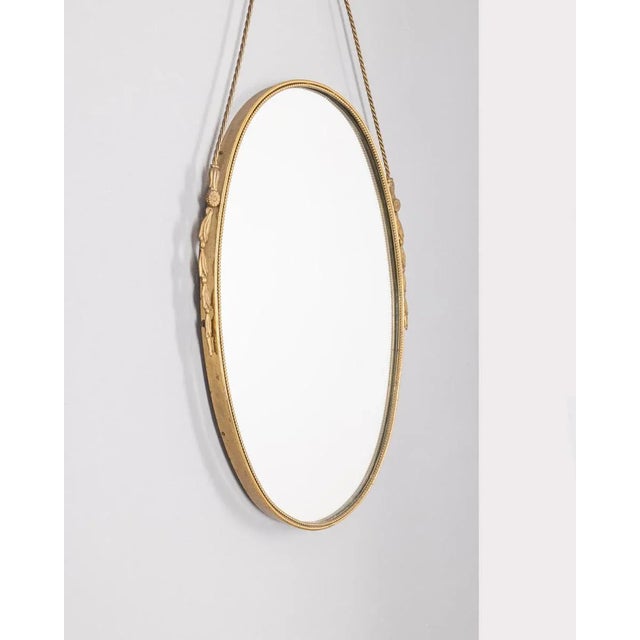 Wall mirror with gilded and decorated brass frame and brass rope, Italian design, 1950s.