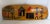 Hand-painted African folk art wall panel featuring a lively village scene with traditional huts and harvest figures. Rich...