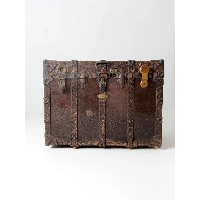 This is an antique trunk. The 19th century steamer trunk features banded bracing, metal corners, leather handles, and...