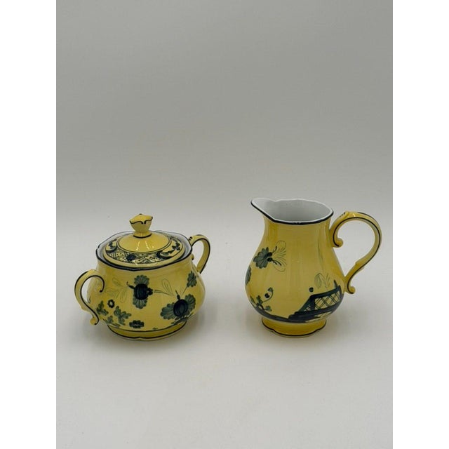 An Italian porcelain covered sugar bowl and creamer by Ginori 1735, decorated in the Oriente Italiano Citrino pattern....