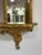 Hollywood Regency ornate gold carved wood mirrored back shelf. Circa 1960’s Measures 12” w x 8” d x 24” h Mirrored back....