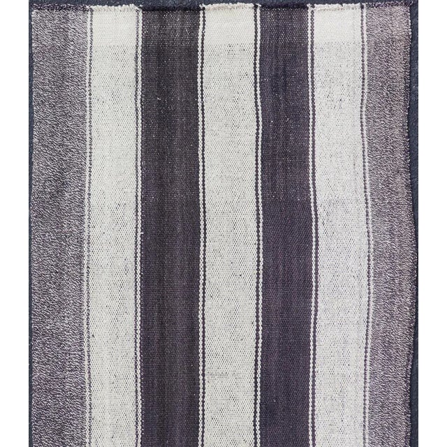 Measures: 2'7 x 6'2 This vintage flat weave Kilim has a very modern stripe design. Rendered in ebony, cream. With neutral...