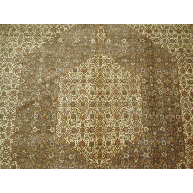 Early 20th century Persian Tabriz with classic Herati motif and timeless medallion and border design. Predominantly brown...