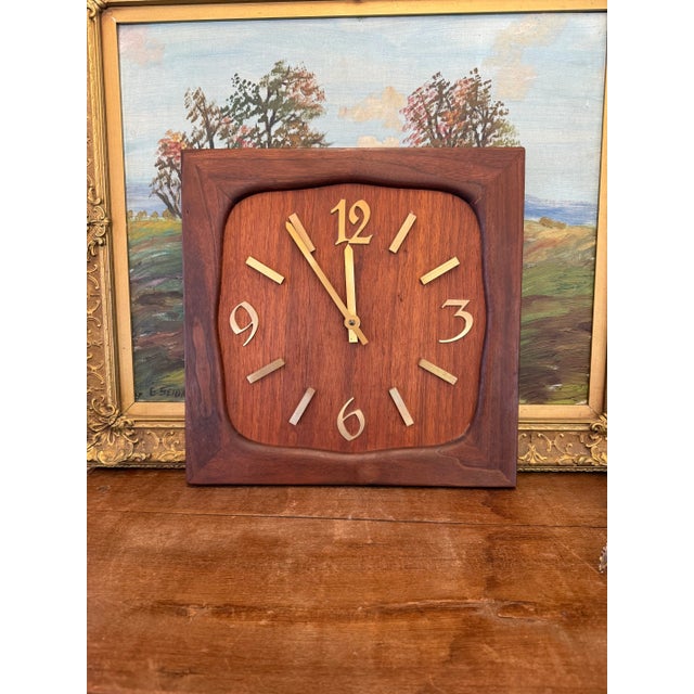 The vintage handmade clock features a square wooden frame with a rich, dark brown finish, showcasing a smooth, polished...